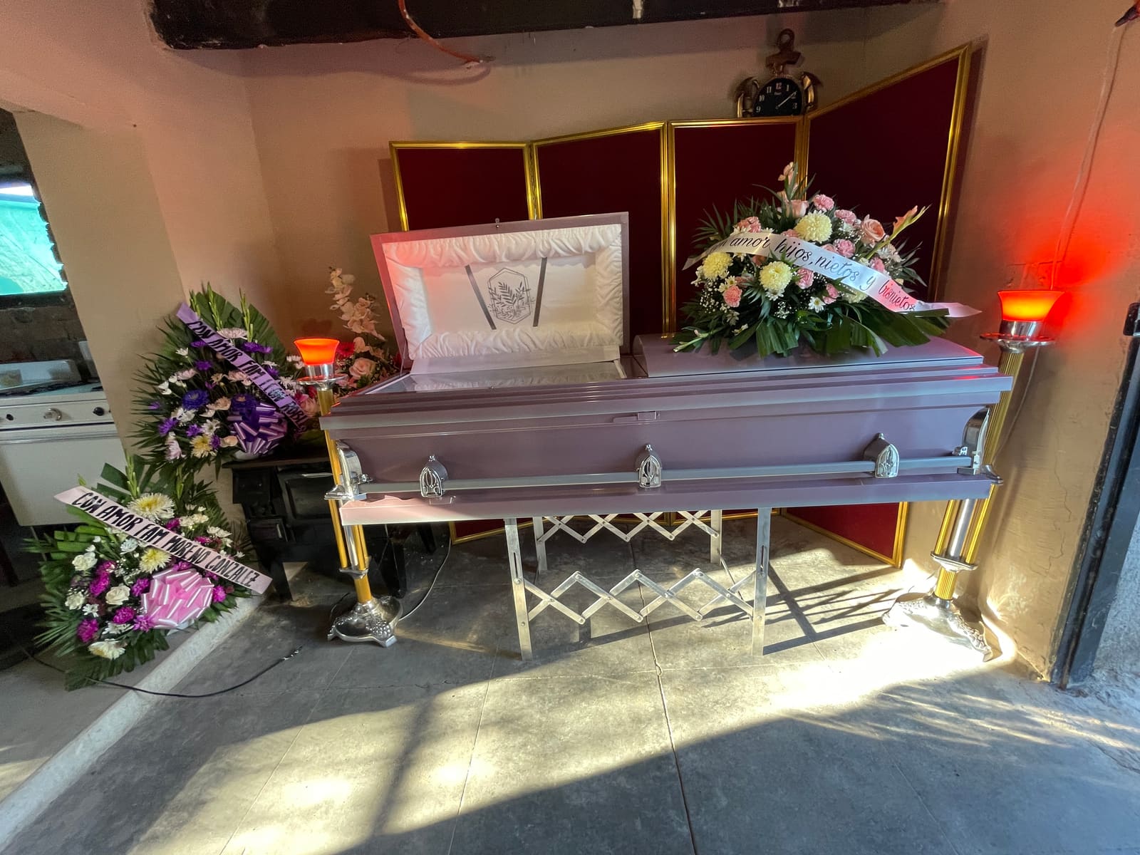 Nana's casket, surrounded by flowers, in the living room